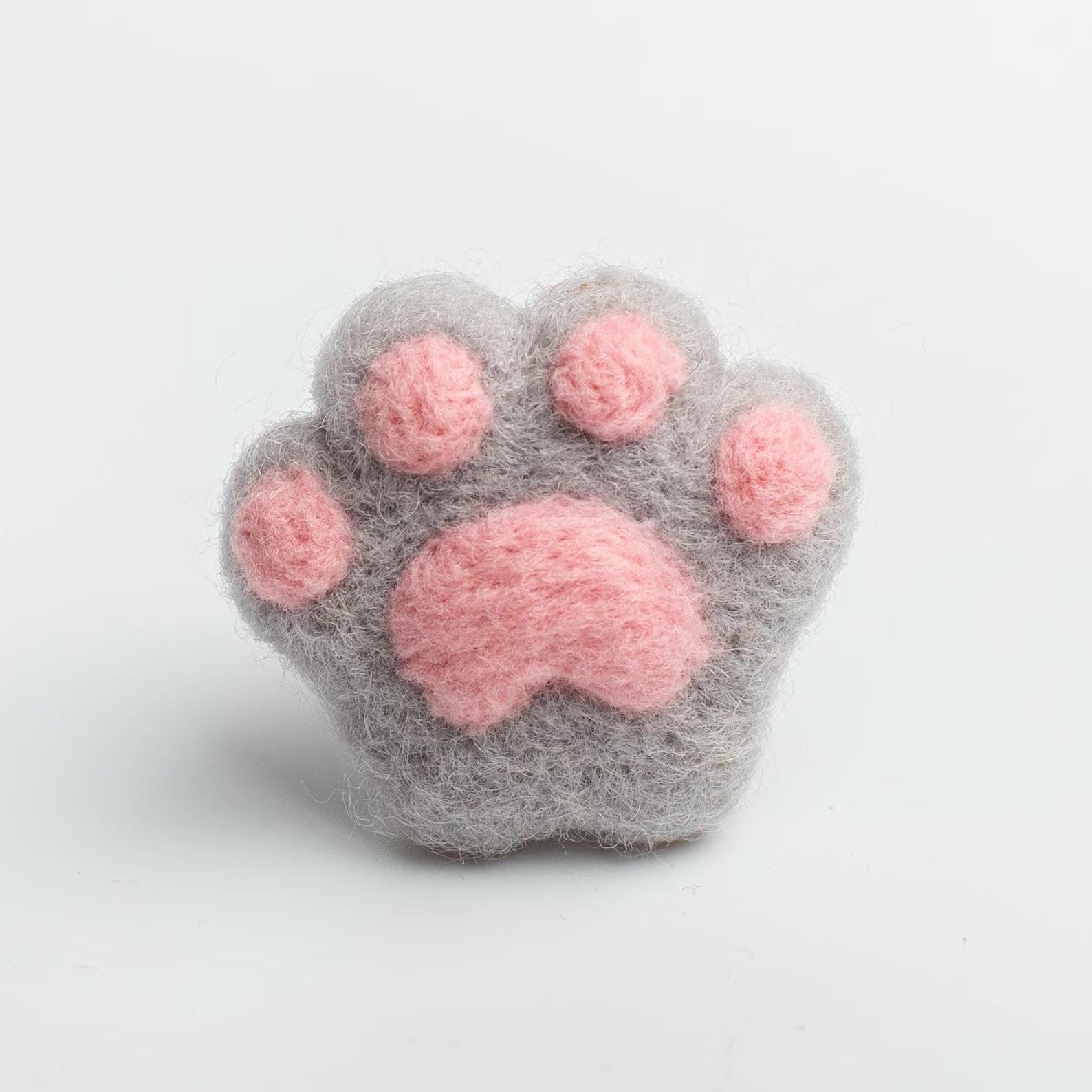A soft gray felt cat paw with pink pads for attached to a car air vent as a cute decorative clip or nature air freshener.