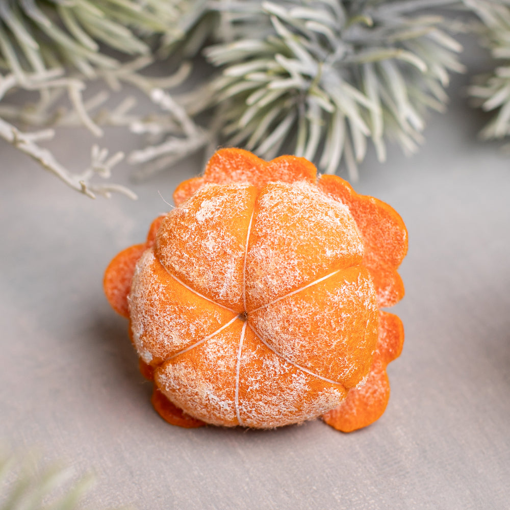 A handmade needle-felted mandarin fruit air freshenerfor for clipped onto a black car air vent. 